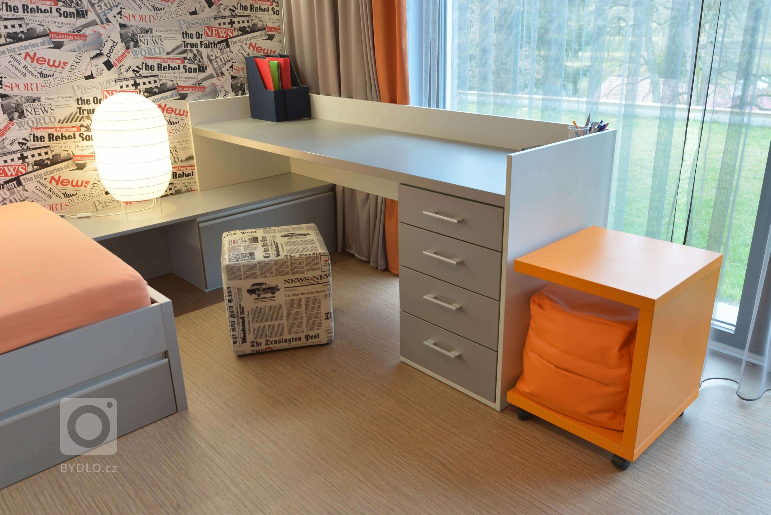 Pracovní stůl s odkládacím stolkem, který lze přesunout i k posteli. Uvnitř je přídavný vak na sednutí pro návštěvy. Pracovní židle byla v době focení jinde. 