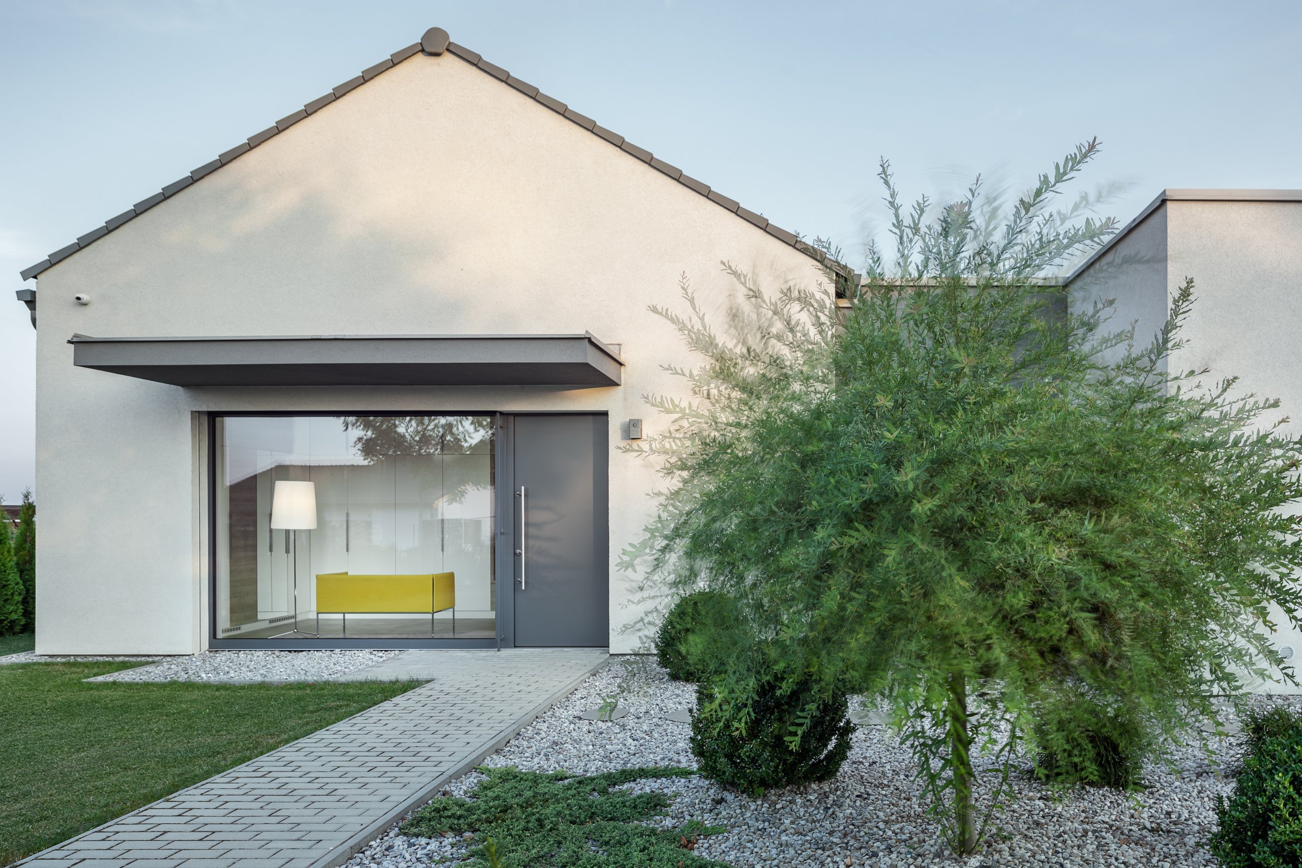 Z pokojů rovnou na zahradu

Přízemní moderní dům s půdorysem do tvaru písmene L se vnitřní stranou otevírá do zahrady skrze velká posuvná okna přes celou šířku…