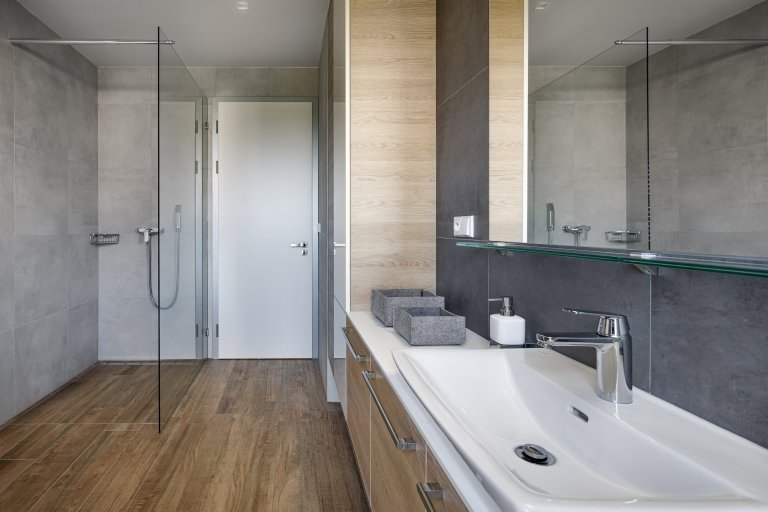 Z pokojů rovnou na zahradu

Přízemní moderní dům s půdorysem do tvaru písmene L se vnitřní stranou otevírá do zahrady skrze velká posuvná okna přes celou šířku…