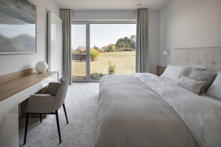 Z pokojů rovnou na zahradu

Přízemní moderní dům s půdorysem do tvaru písmene L se vnitřní stranou otevírá do zahrady skrze velká posuvná okna přes celou šířku…