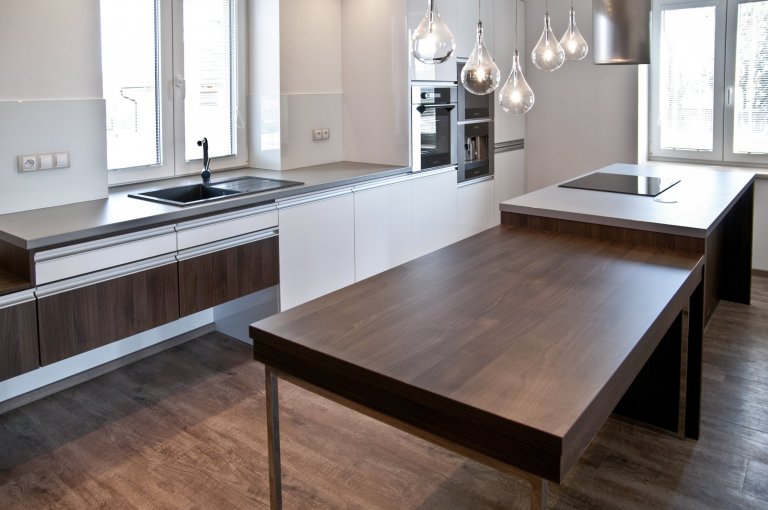 Velice moderní kuchyňská sestava působící luxusním dojmem. Majitelé vsadili na bílou lesklou barvu a velmi oblíbený dekor ořechu Ribera. Krásu kuchyně pak…
