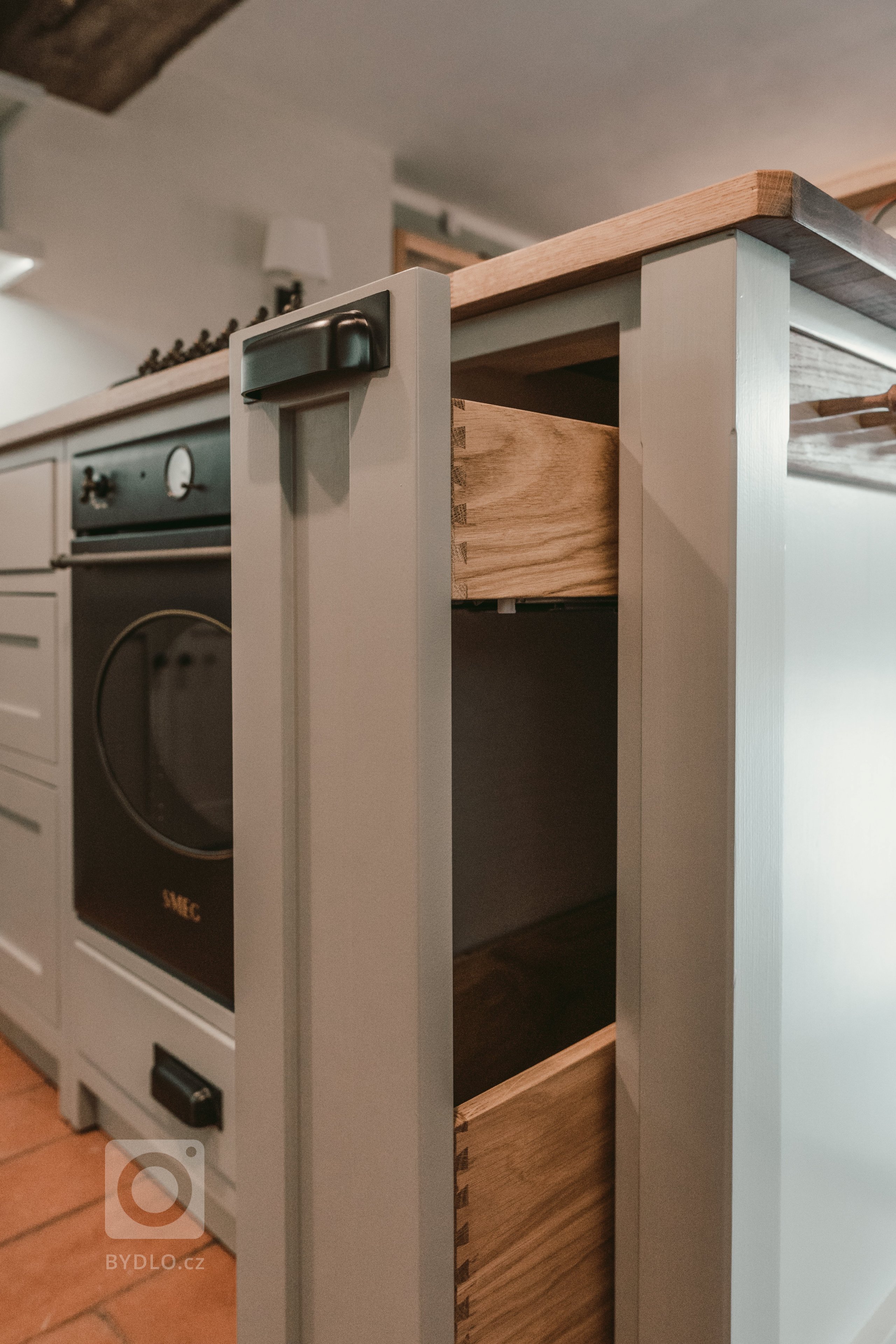 Tato krásná kuchyně propojuje kombinaci dubového dřeva, ručního nátěru a přírodního kamene. Dubová prosklená kredenc nabízí spoustu úložného prostoru a díky…