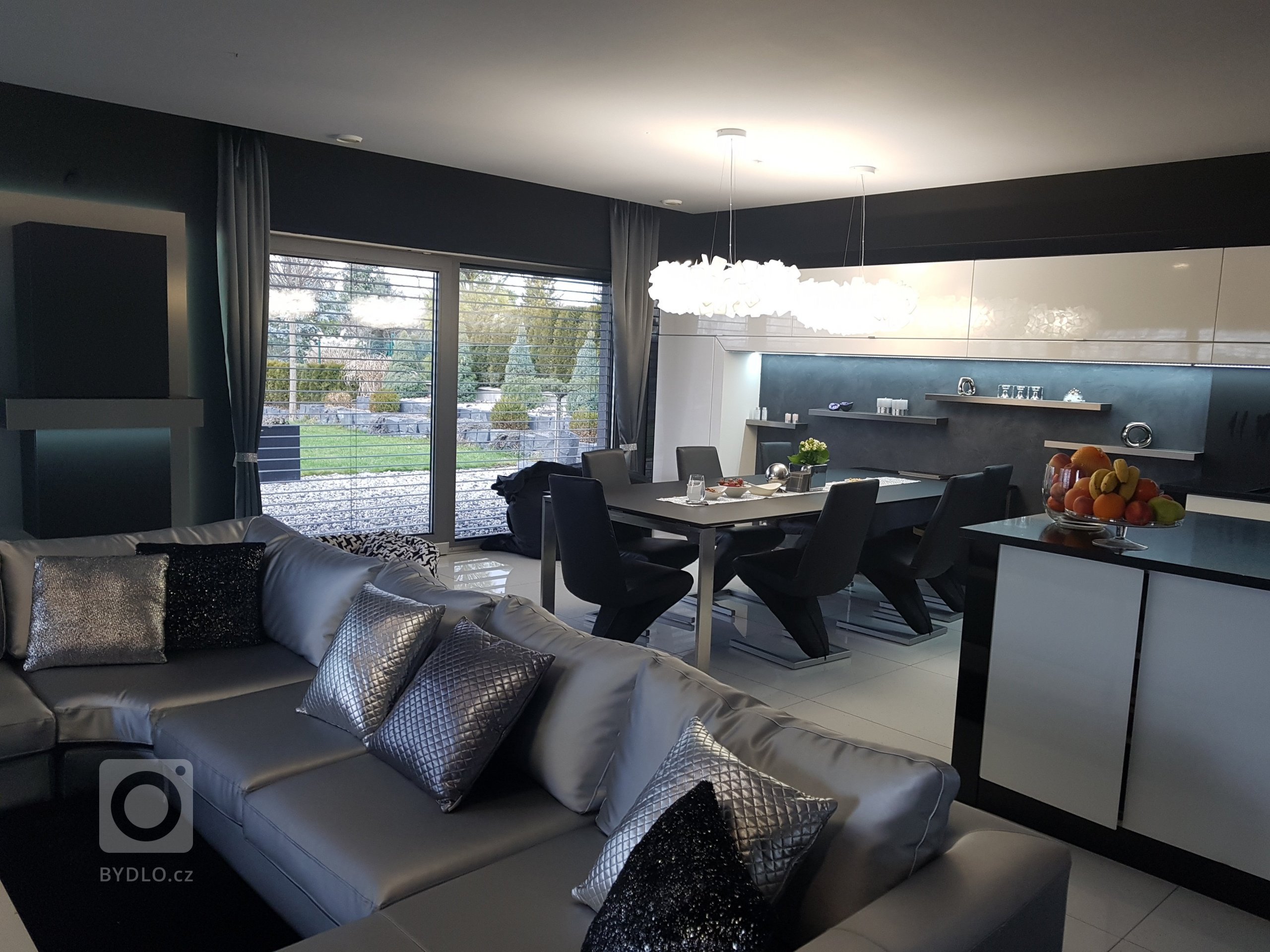 Okna jsou doplněna pouze pruhy závěsů v kovově-lesklém provedení. 