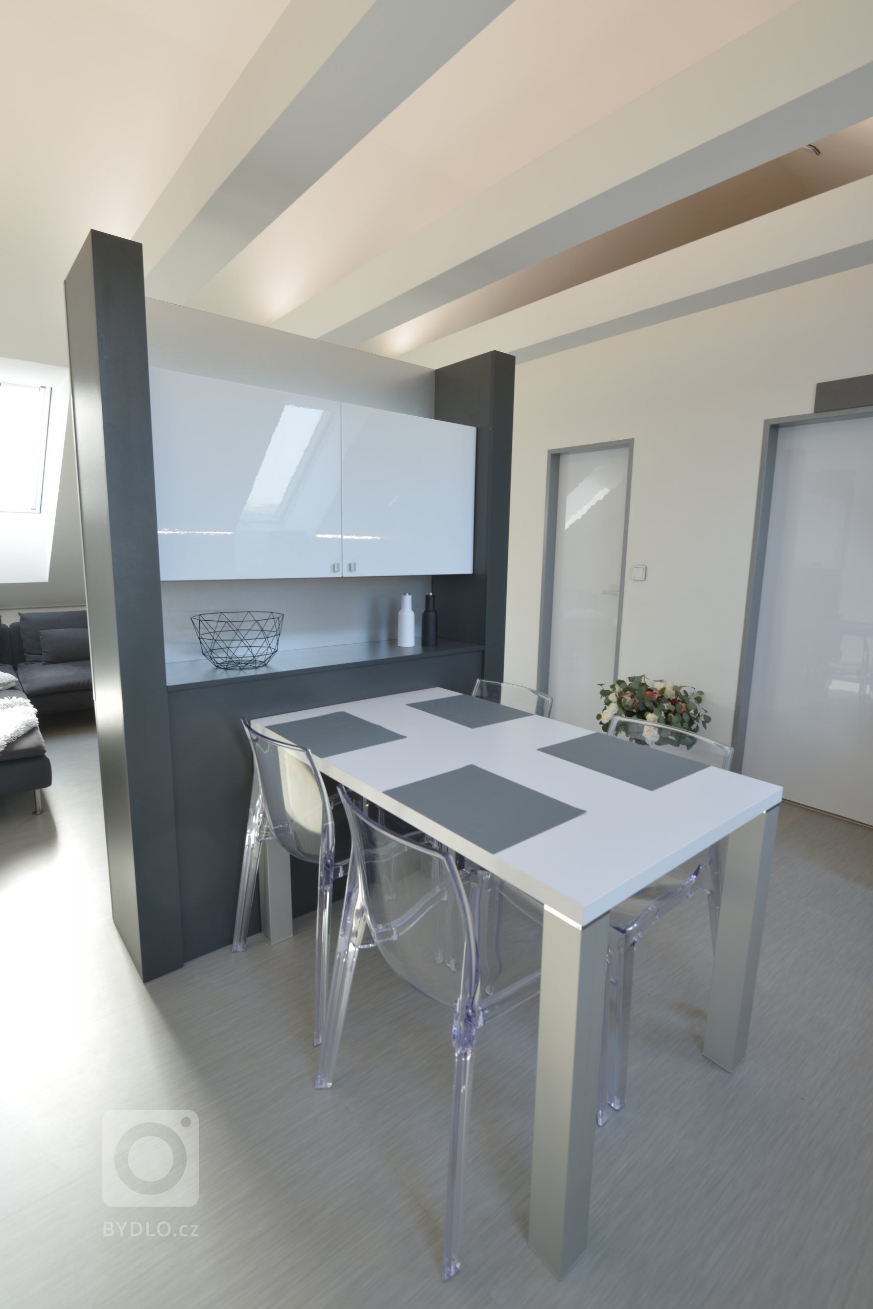 Prostor je rozdělený oboustrannou sestavou, která slouží na televizi a techniku z obývací části a jako jídelna v kuchyňské části. 