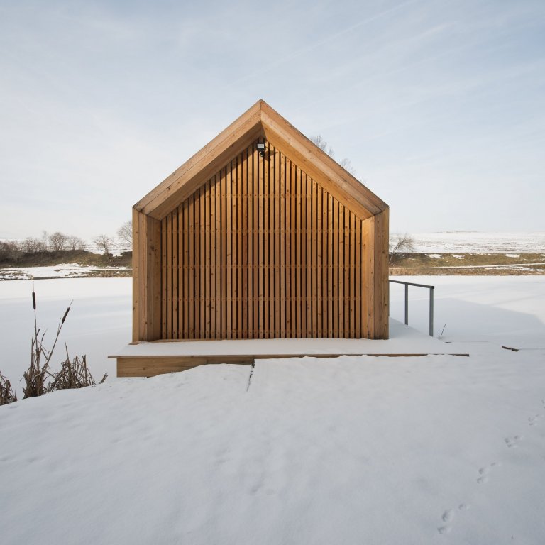 Inspirováná tradičními rybářskými boudami na břehu rybníka, zasazeného v&nbsp;malebné krajině&nbsp;Vysočiny
