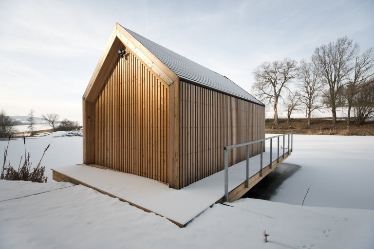 Inspirováná tradičními rybářskými boudami na břehu rybníka, zasazeného v&nbsp;malebné krajině&nbsp;Vysočiny
