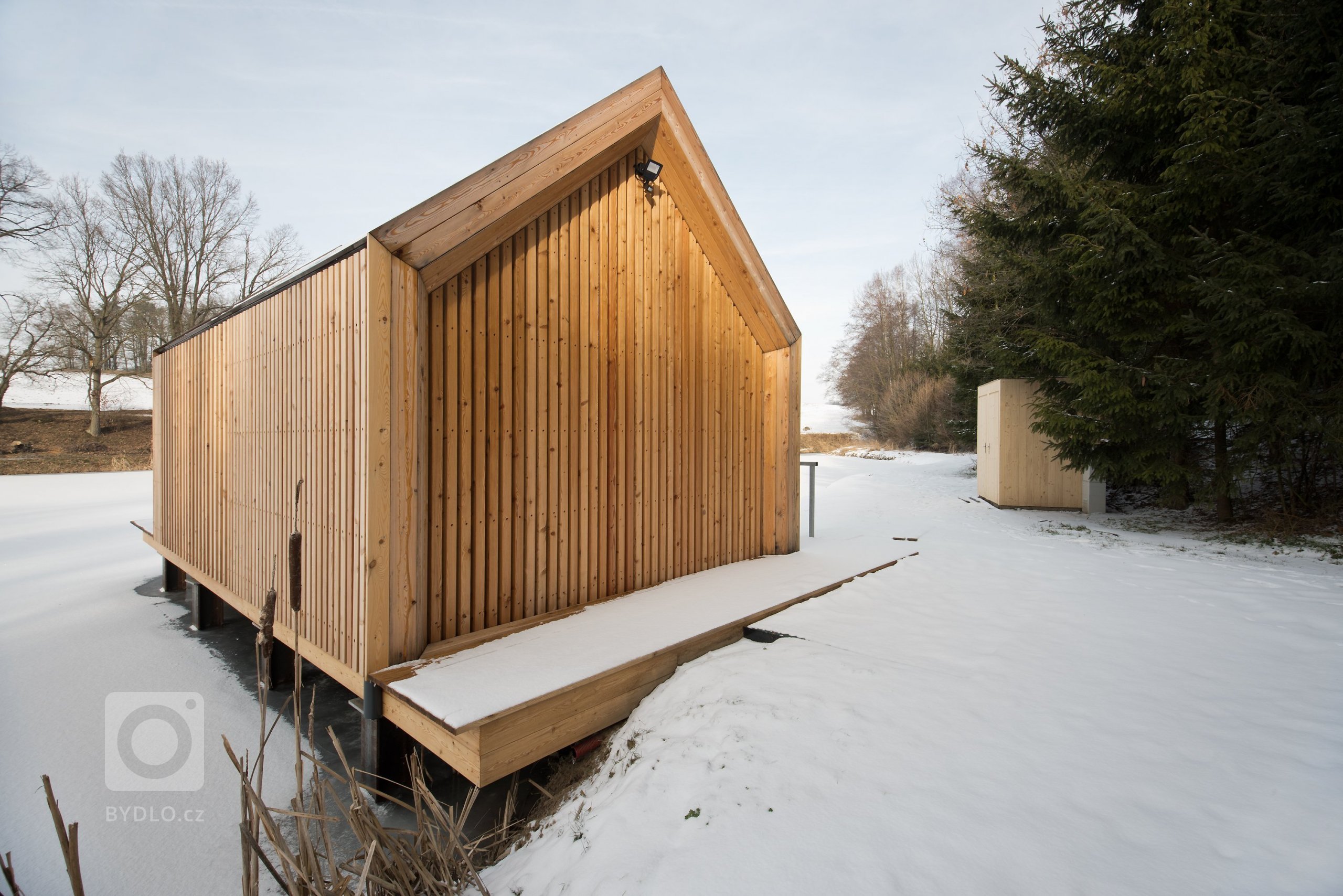 Inspirováná tradičními rybářskými boudami na břehu rybníka, zasazeného v&nbsp;malebné krajině&nbsp;Vysočiny
