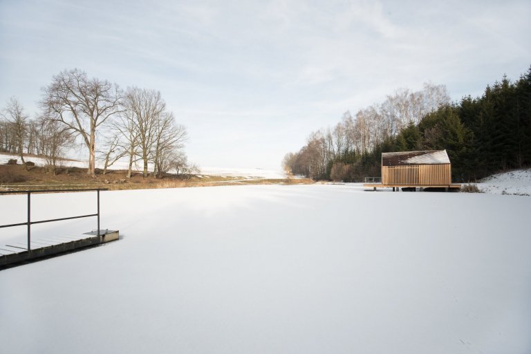 Inspirováná tradičními rybářskými boudami na břehu rybníka, zasazeného v&nbsp;malebné krajině&nbsp;Vysočiny
