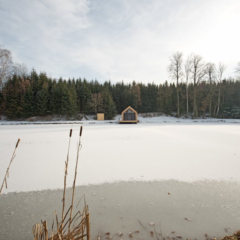 Inspirováná tradičními rybářskými boudami na břehu rybníka, zasazeného v&nbsp;malebné krajině&nbsp;Vysočiny
