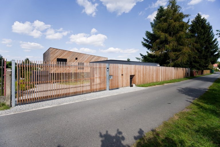 Architektonické řešení navazuje na zahrádkářskou minulost parcely a koncept projektu řadových domů. Protáhlá obdélníková stavba má plně prosklené přízemí, na…