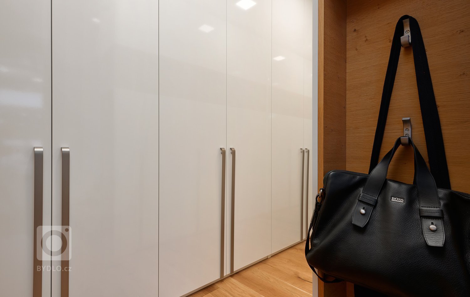 Interiér, kde se prolíná dýha dub rustikální přírodní spolu s bílým lakem ve vysokém lesku. Kuchyně získala v tomto prostorném domě místo při schodišti, které…