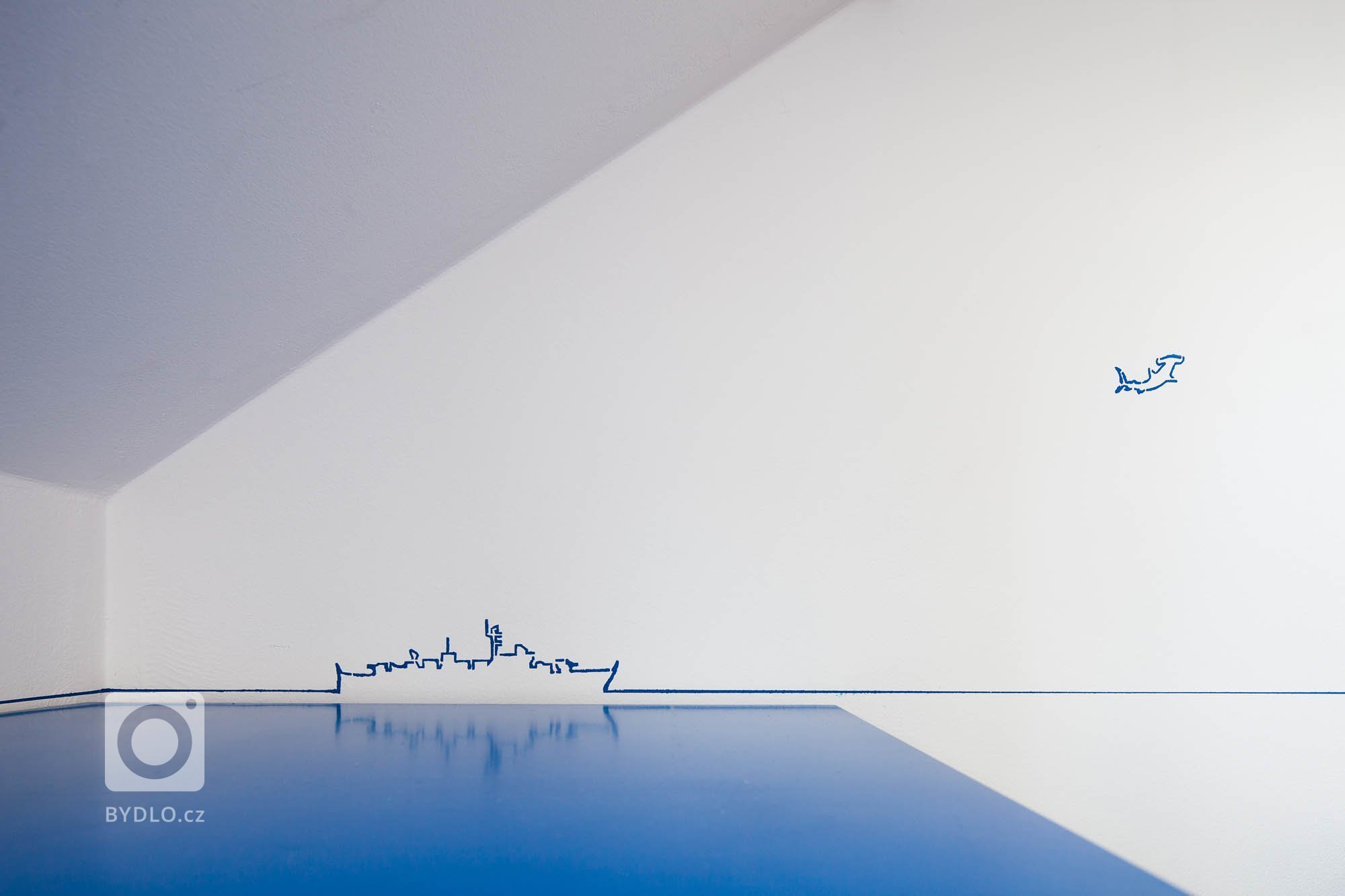 Zadáním byla pracovna v námořnickém stylu. Typickou modro-bílou kombinaci barev doplňuje neutrální šedá barva sedacího nábytku a přírodní barva dřeva podlahy a…