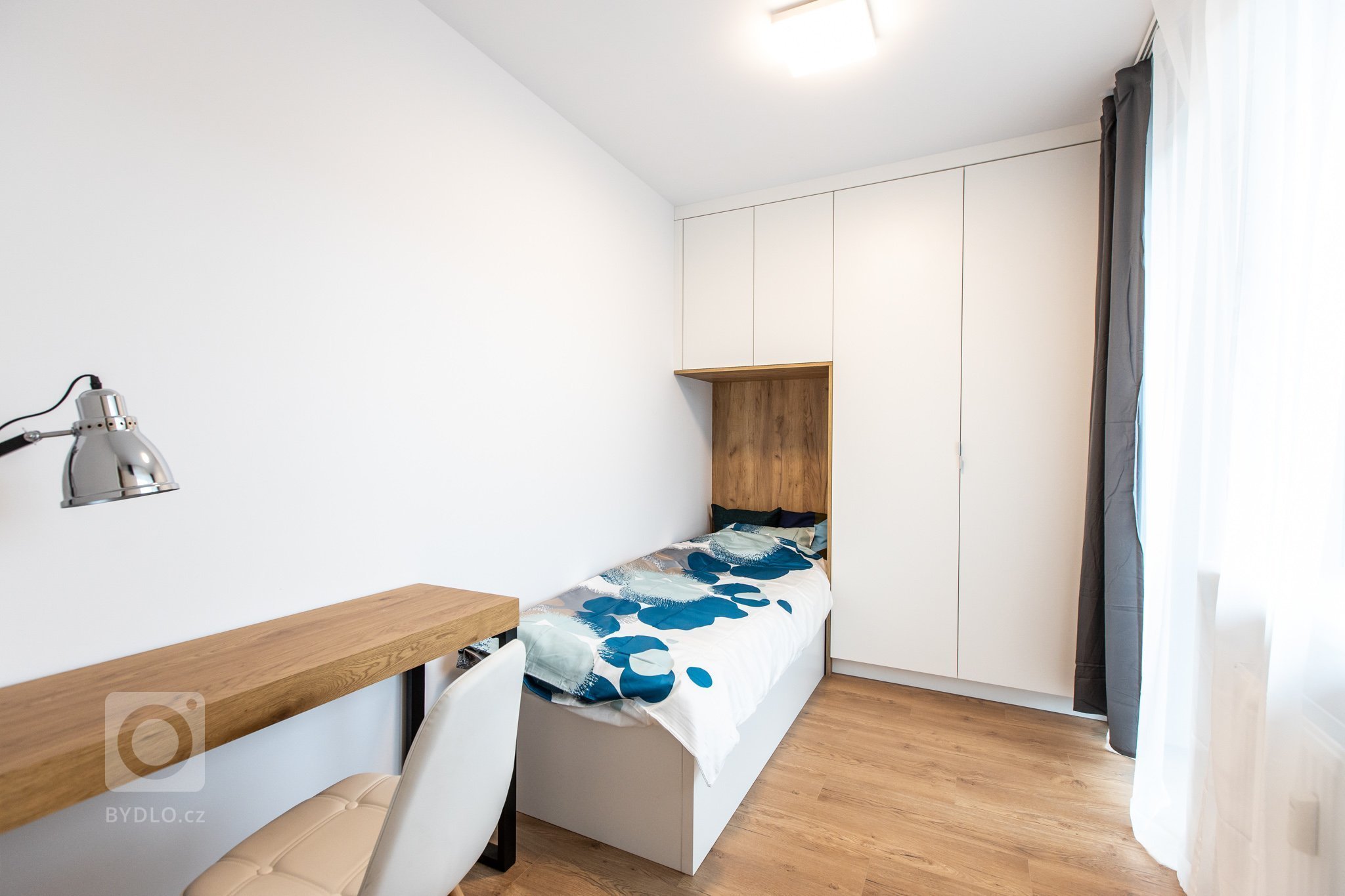 Krásna realizácia, ktorá dokonale prepája antracitovú kuchyňu s bielou obývacou zostavou.
