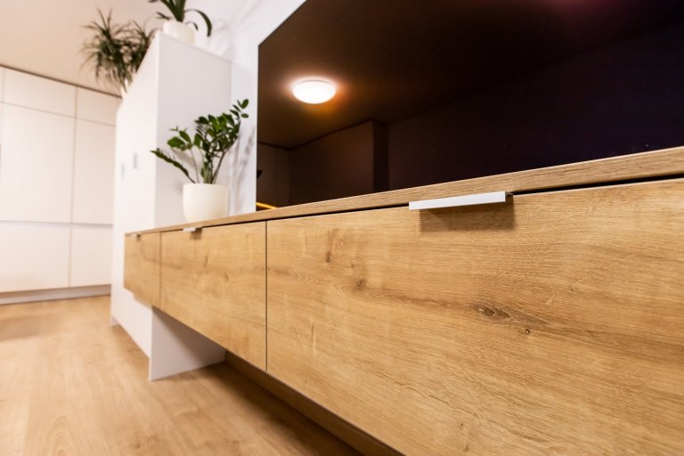Materiály: Biely perleťový mat a Dub zlatý

Podsvietenie: Teplý&nbsp;LED pás

Madlá: Kuchyňa - Zafrézované hliníkové

Skrine - Madlo v tvare &quot;L&quot…