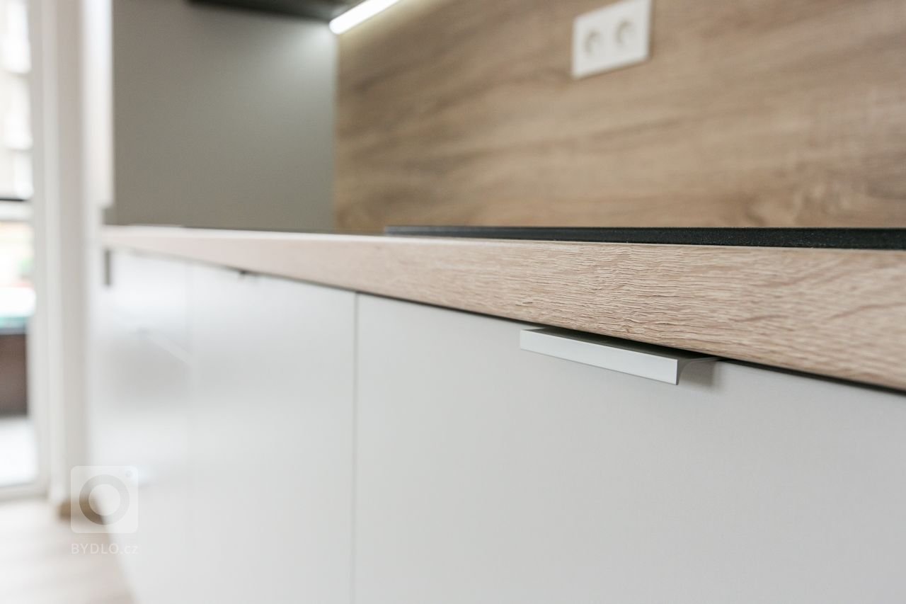 Použité materiály:

Horné skrinky: antracitový mat
Dolné a vysoké skrinky:&nbsp;biely perleťový mat
Vstavané skrine: biely perleťový mat
Výklenok: dub…