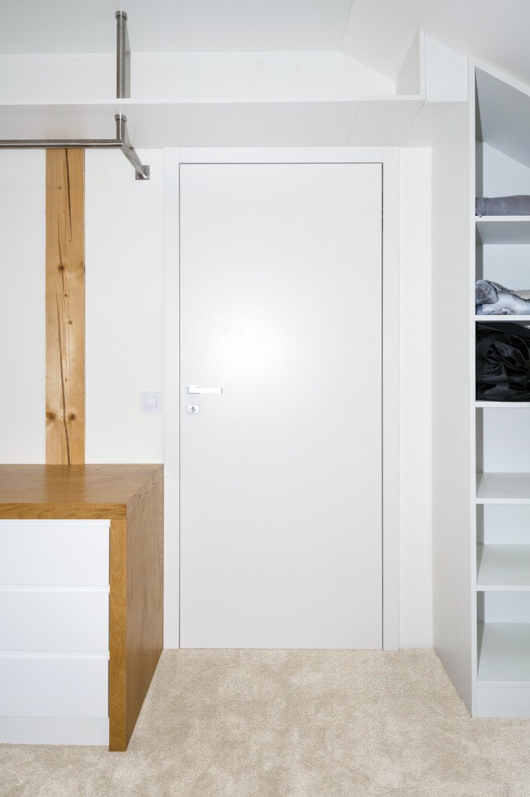 Šatna v&nbsp;podkrovním bytě se nachází mezi dvěma ložnicemi, které propojuje. Světlý pokoj poskytuje mnoho místa na ukládání oblečení a doplňků. Důraz při…