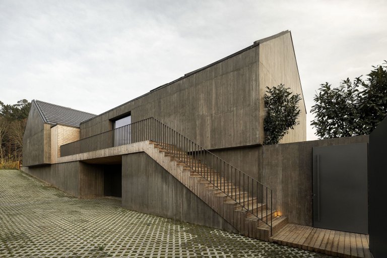 Dům s dřevěnou fasádou a geometrickými světlíky