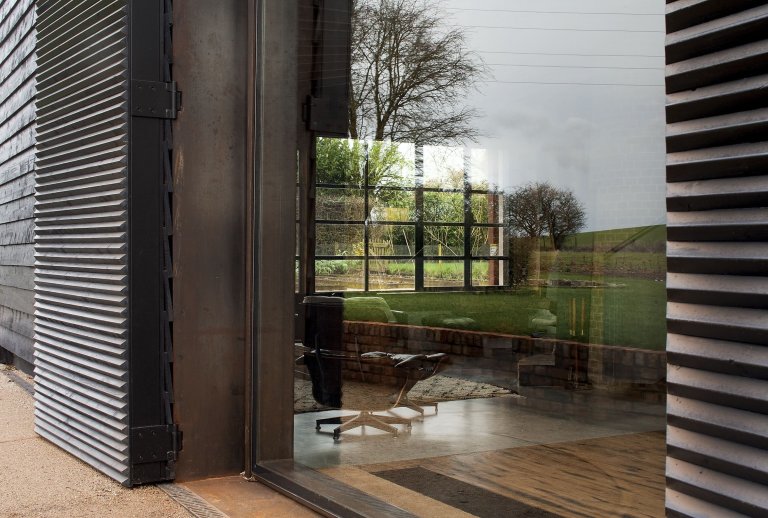 Stodola s podlahou ze starého mostu a stolem z bowlingové dráhy