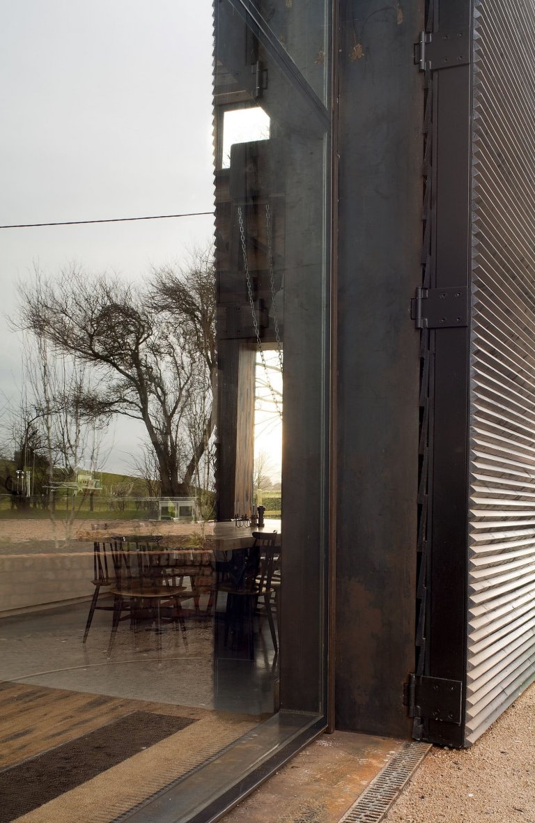 Stodola s podlahou ze starého mostu a stolem z bowlingové dráhy