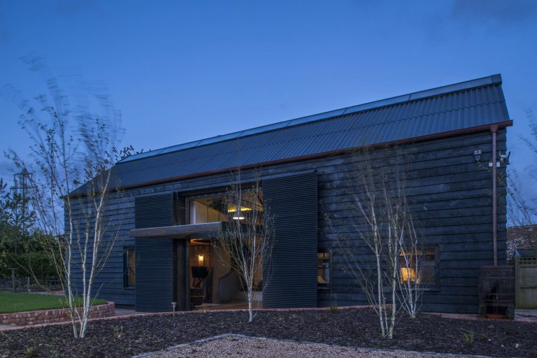 Stodola s podlahou ze starého mostu a stolem z bowlingové dráhy