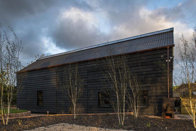 Stodola s podlahou ze starého mostu a stolem z bowlingové dráhy