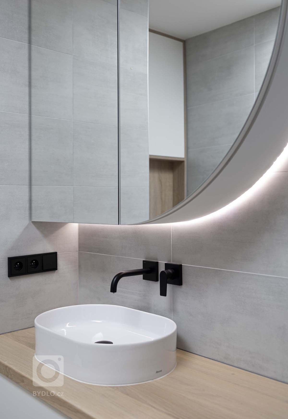 Koupelna je navržena v&nbsp;přírodních tónech dekoru dubu, který se propisuje na dlažbě na podlaze a&nbsp;obložení nik či&nbsp;toalety. Dále pak na desce…