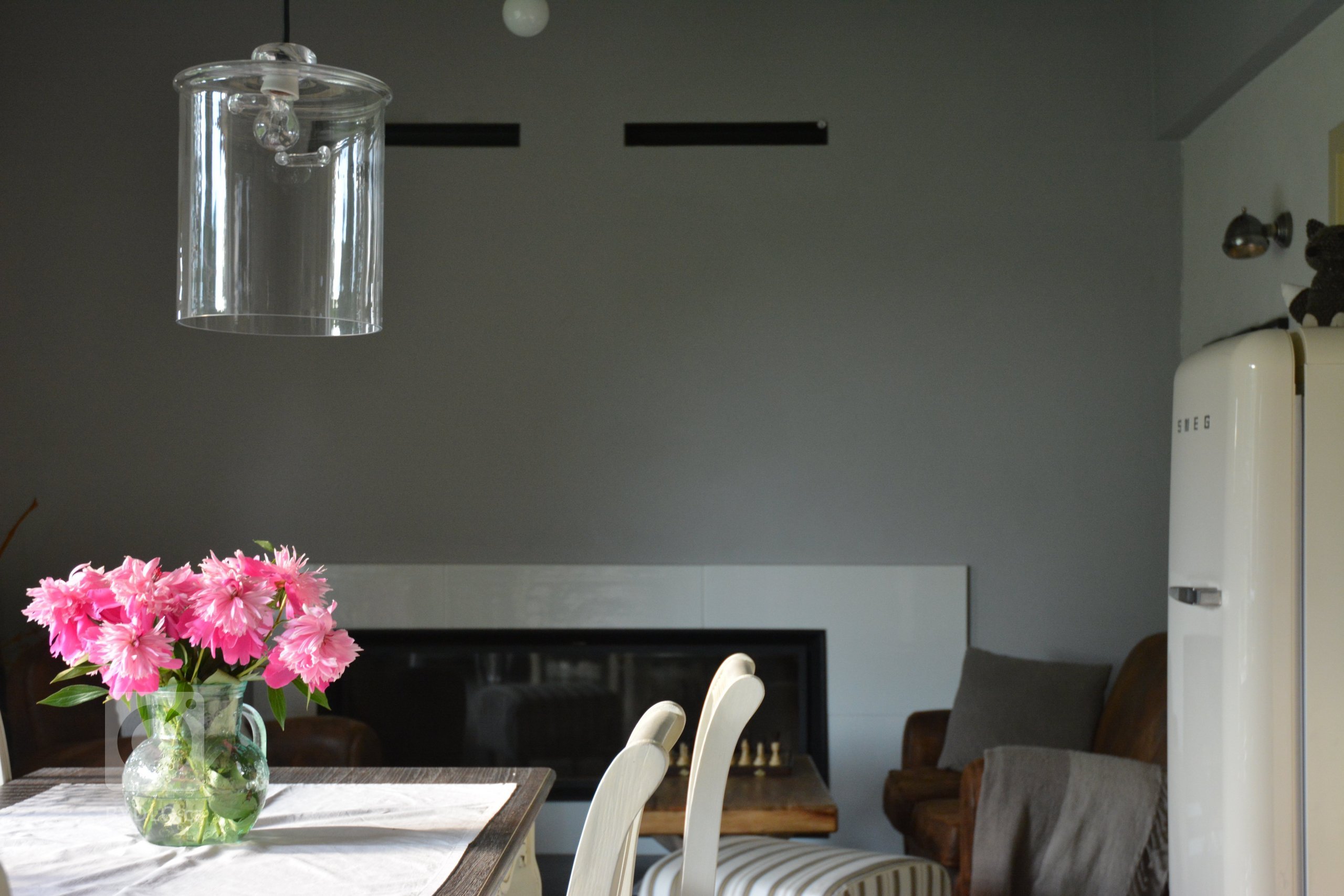 Detail na na obýváková kout s koženou sedačkou a krbem s panoramatickým prosklením.