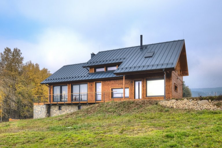 Prostorný dům v šumavské stráni postavený z masivních hranolů finské, polární borovice.
