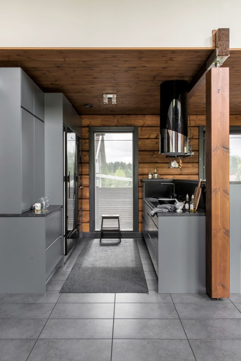 Kouřově šedé dlaždice ladí s kuchyňskou linkou rovněž šedé barvy. Černá barva lednice a mrazáku dodávají interiéru jiskru. 