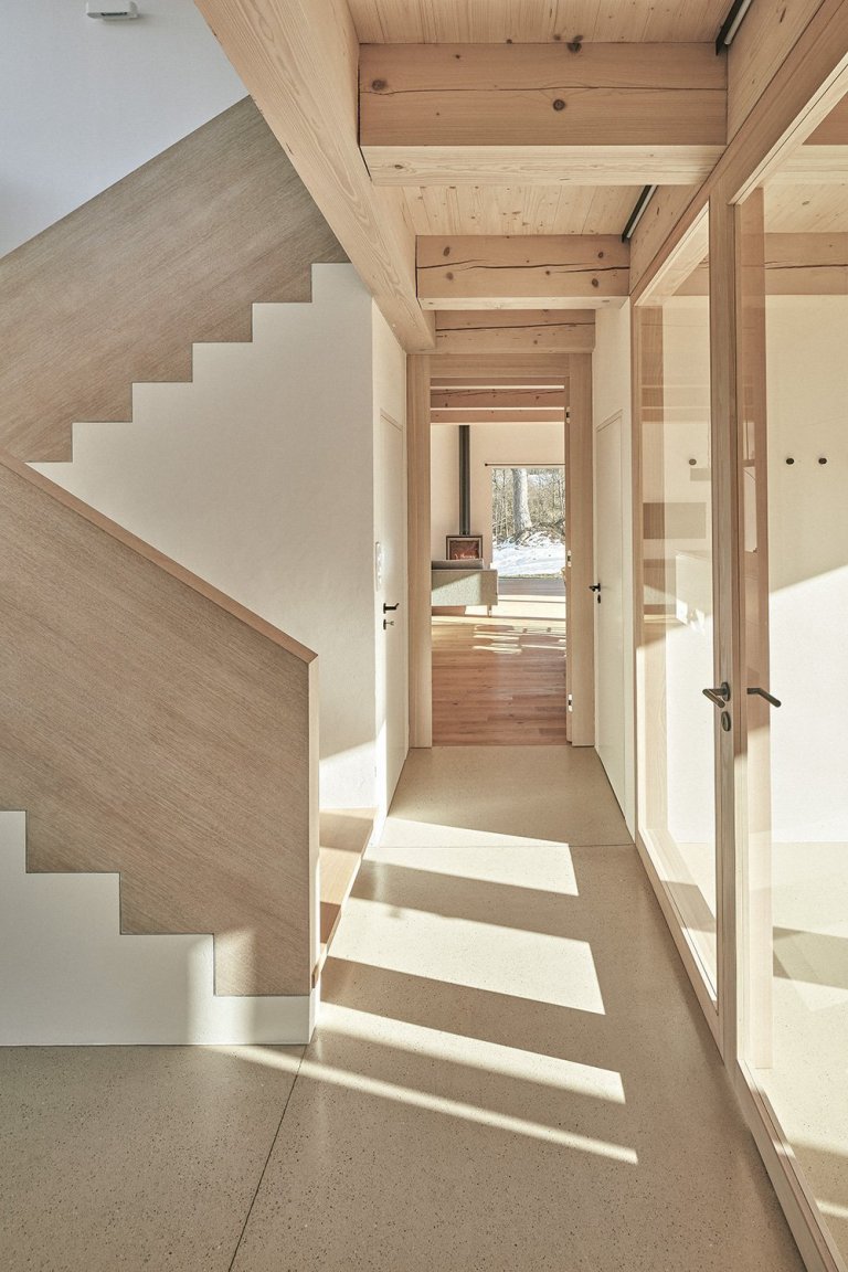 Pozemek leží na hraně svahu v&nbsp;centru malé obce na Vysočině. Na půdorysné stopě bývalého statku vznikl dům a stodola. Dům má podél jihozápadní fasády kryté…