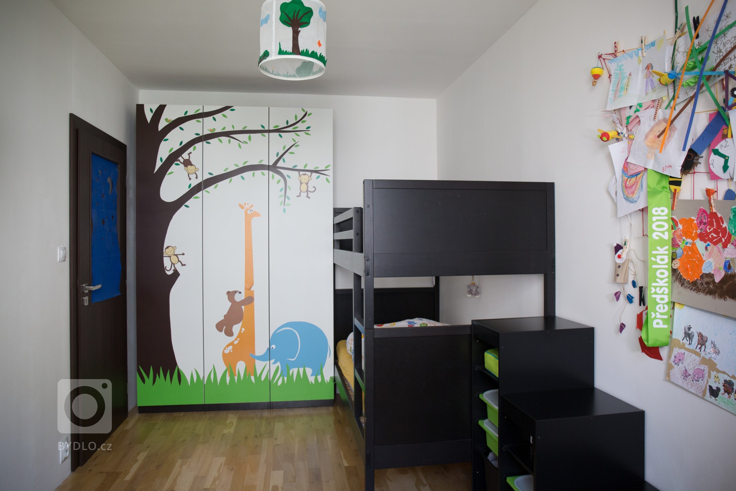 Dětský pokoj v černobílé kombinaci doplňuje vlastní autorská aplikace na šatní skříni