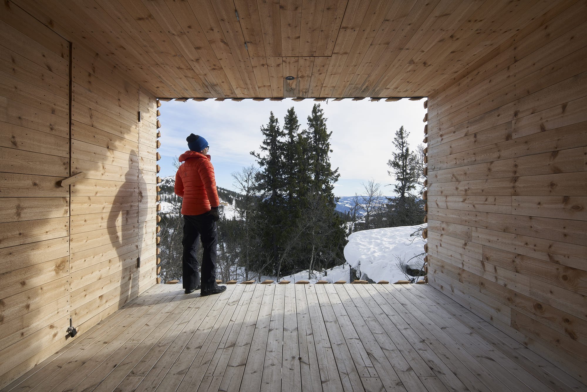 Chata zabalená plotem odolává drsným podmínkám na vrcholku hory