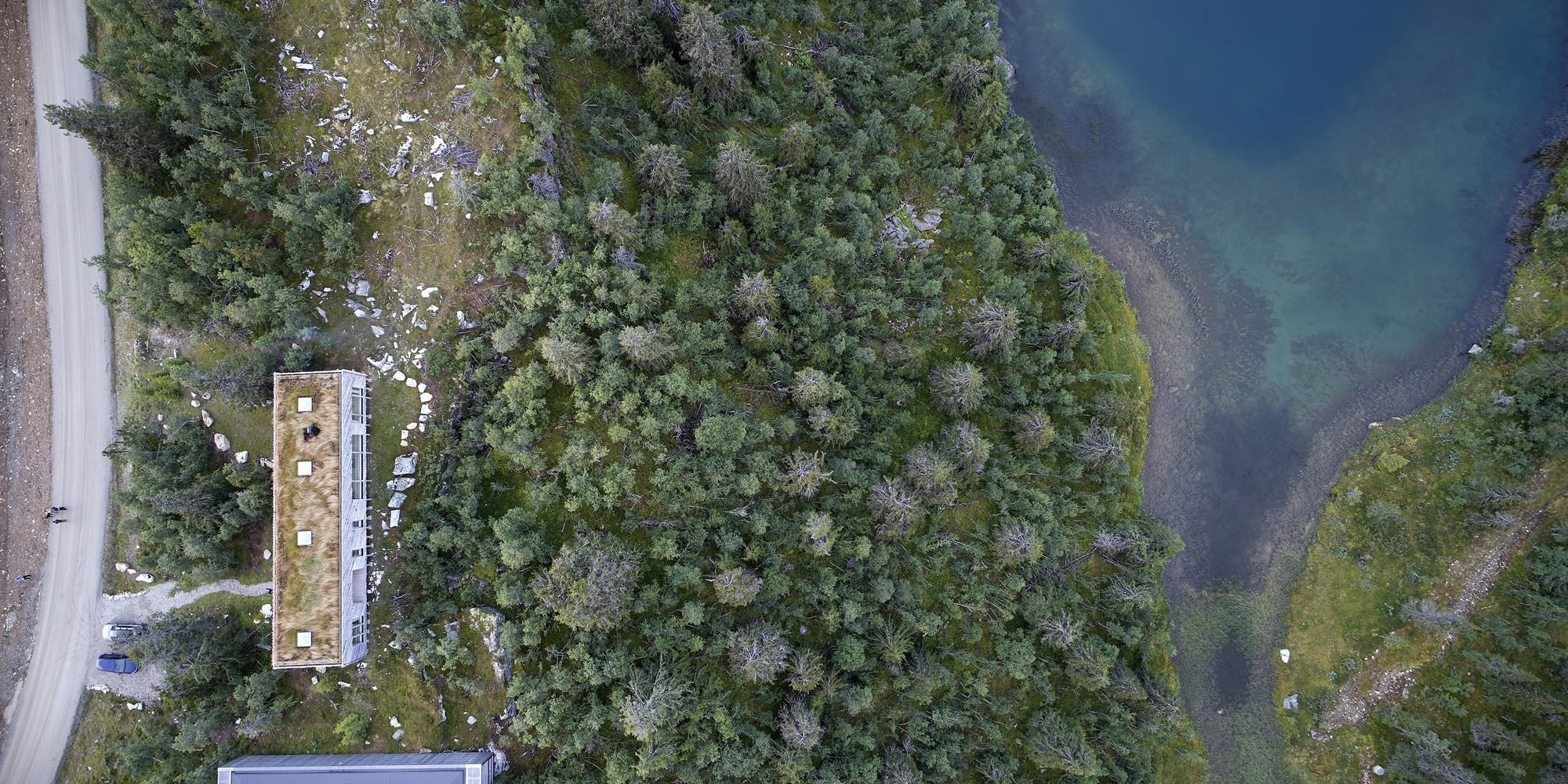 Chata zabalená plotem odolává drsným podmínkám na vrcholku hory