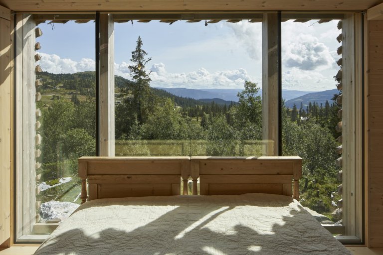 Chata zabalená plotem odolává drsným podmínkám na vrcholku hory