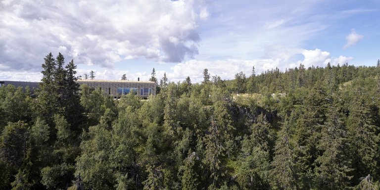 Chata zabalená plotem odolává drsným podmínkám na vrcholku hory