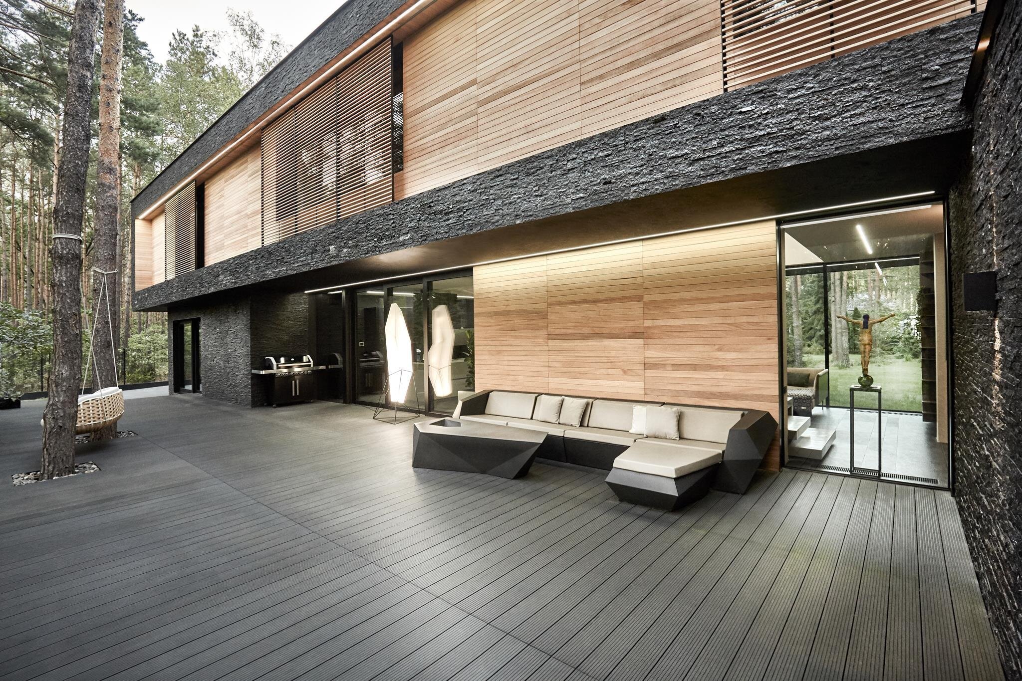 Dům s fasádou z břidlice uprostřed lesa