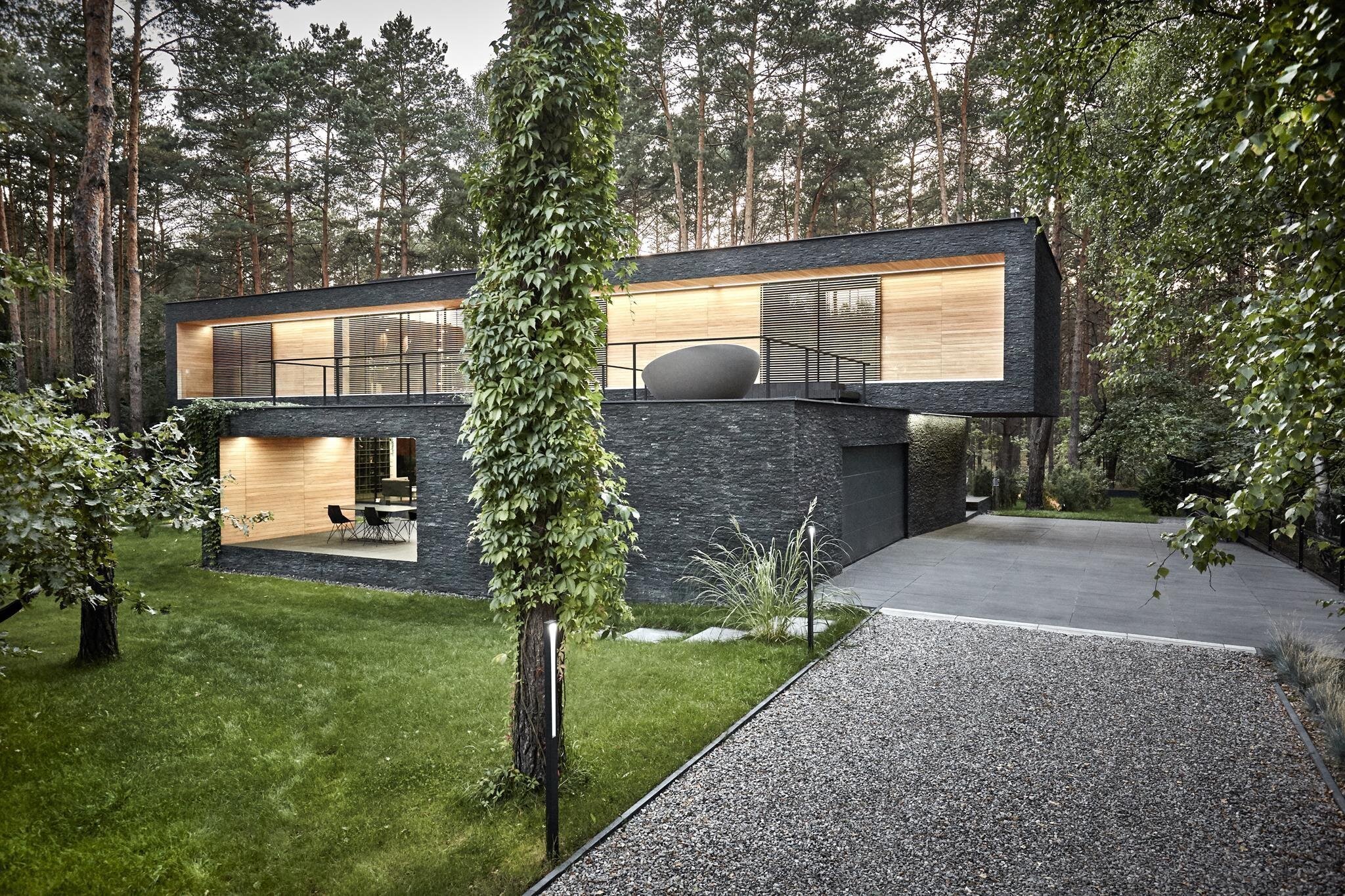 Dům s fasádou z břidlice uprostřed lesa