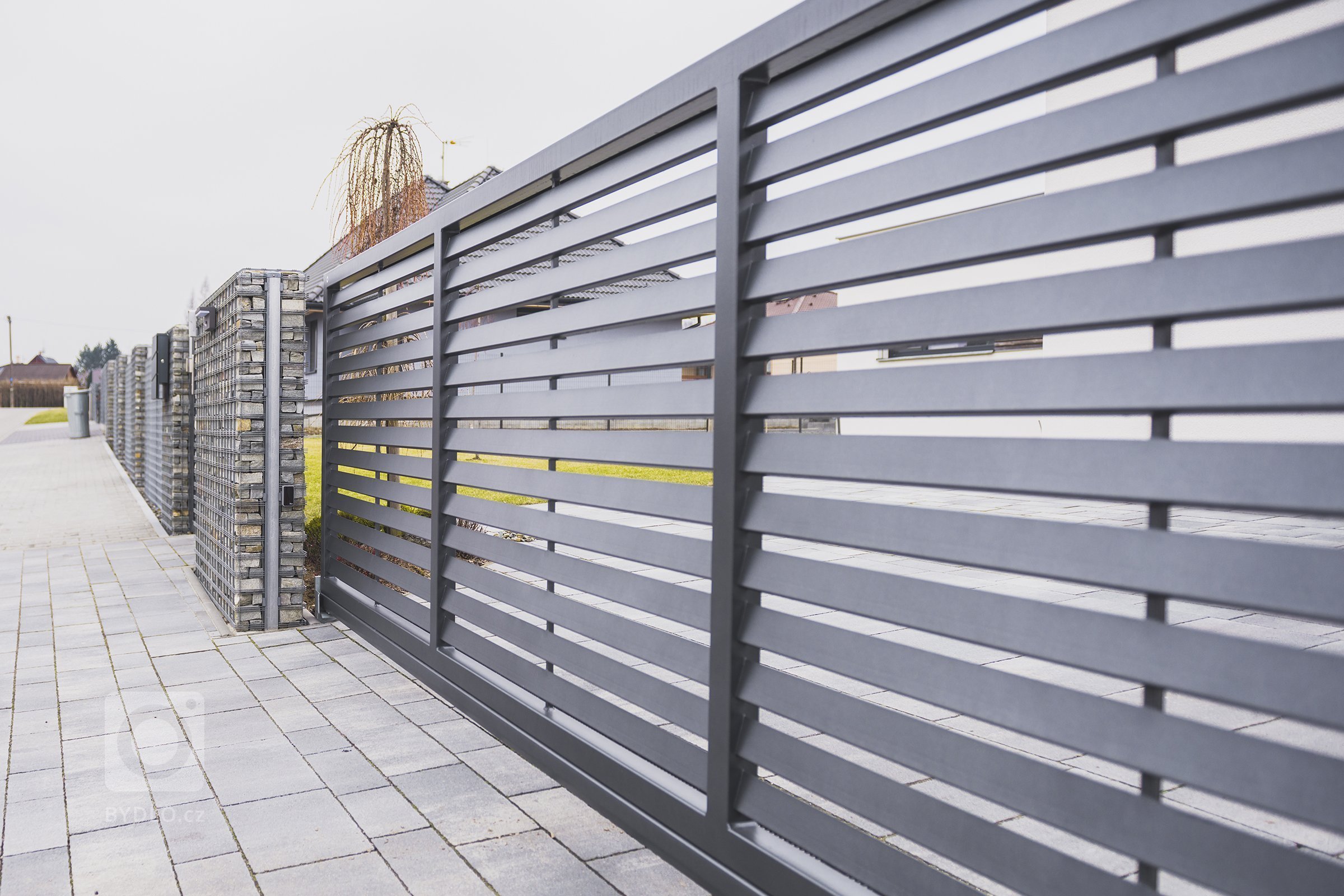 Brána s brankou Half (rodinný dům, Havířov).

Když dodáváte&nbsp;klientovi na míru, musí vše sedět jako ulité. Funkčně, esteticky a v celé řadě dalších rovin…