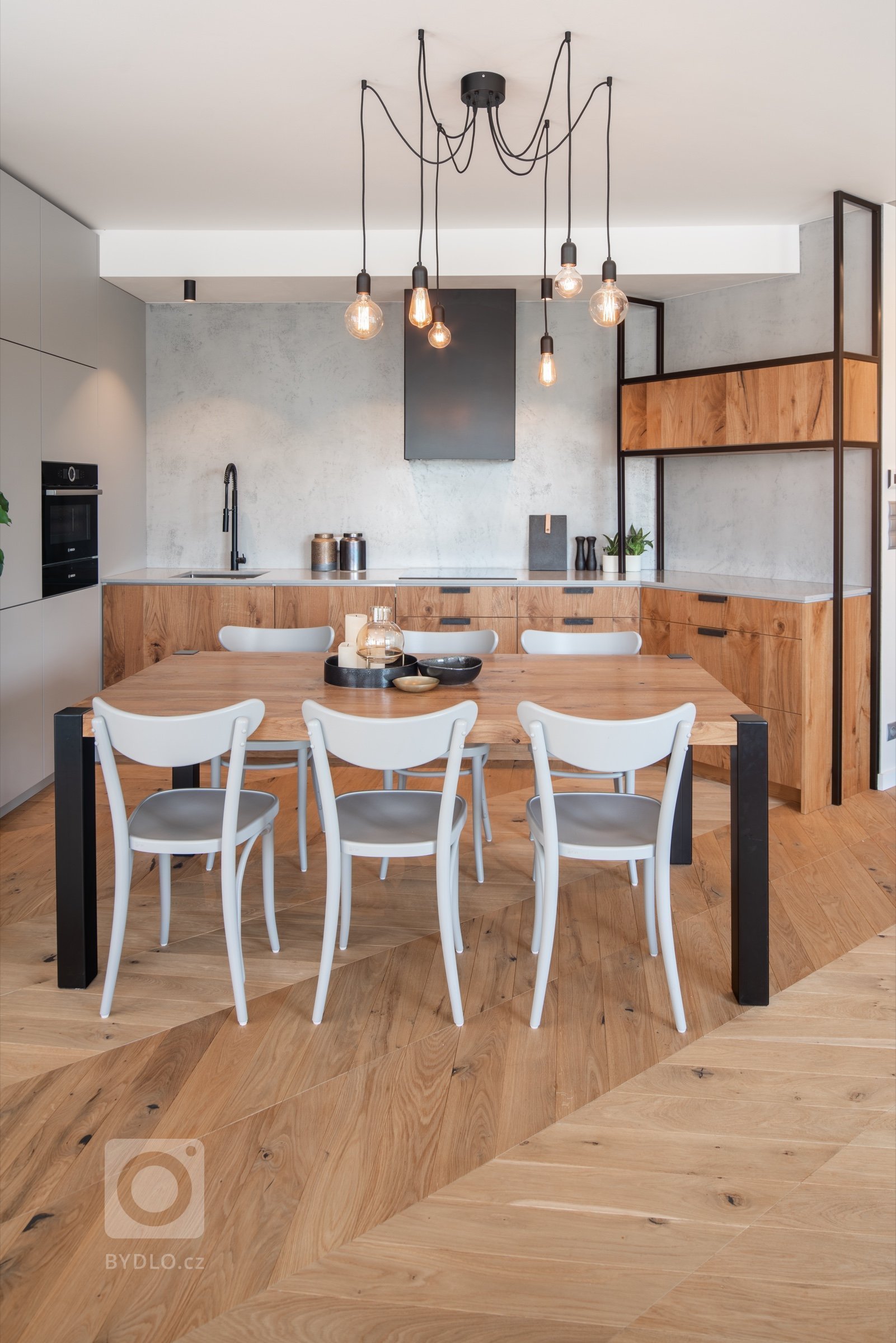 Jídelní stůl pro 6 až 8 osob byl vyroben ve stejném duchu, jako zbytek interiéru, na míru z masivního dubového dřeva a oceli. 