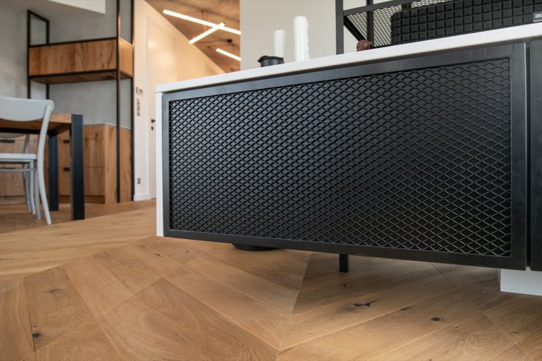 Televizní stěna je obestavěná knihovnou tvořenou konstrukcí z ocelového jeklu a tahokovu. 