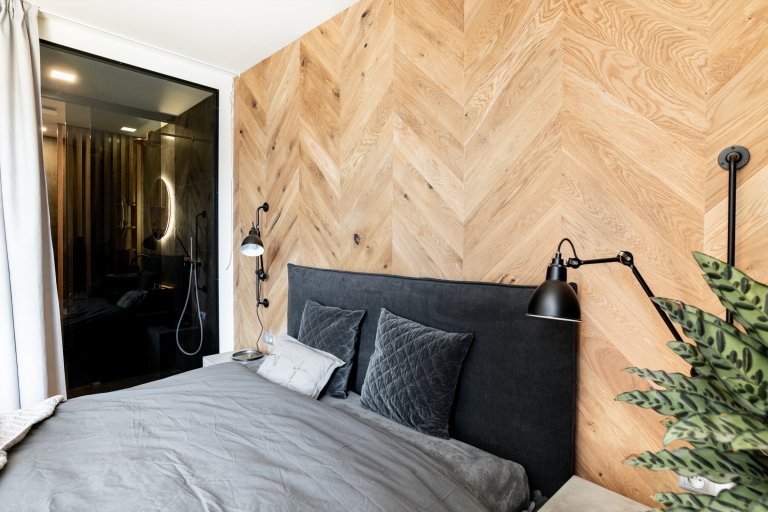 Postel s vysokým čalouněným čelem byla vyrobena na míru v souladu s designem ostatních místností.