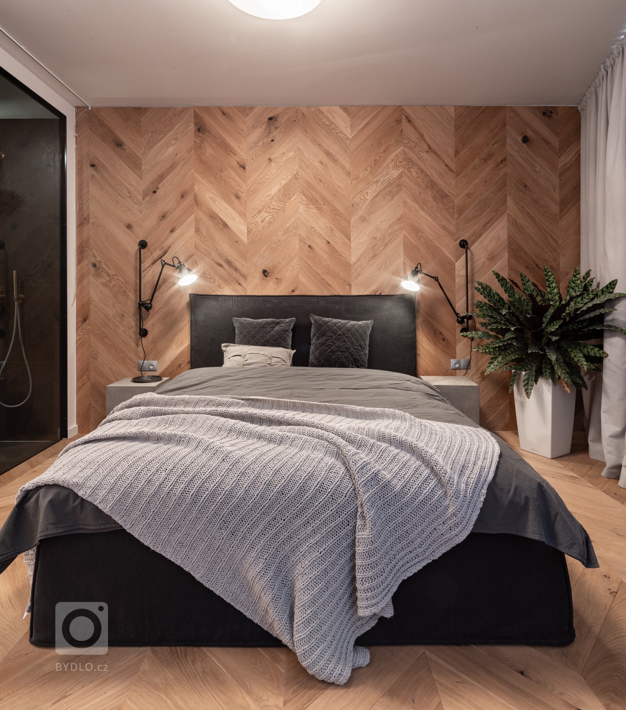 Postel s vysokým čalouněným čelem byla vyrobena na míru v souladu s designem ostatních místností. 