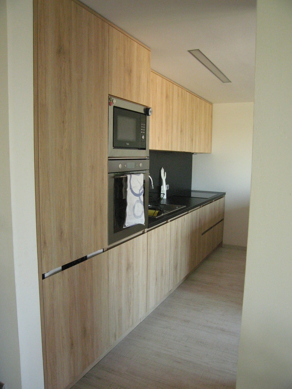 Dle návrhu architekta bylo vytvořeno zkosení na horní hraně dvířek, které vytvořilo prostor pro uchycení.
