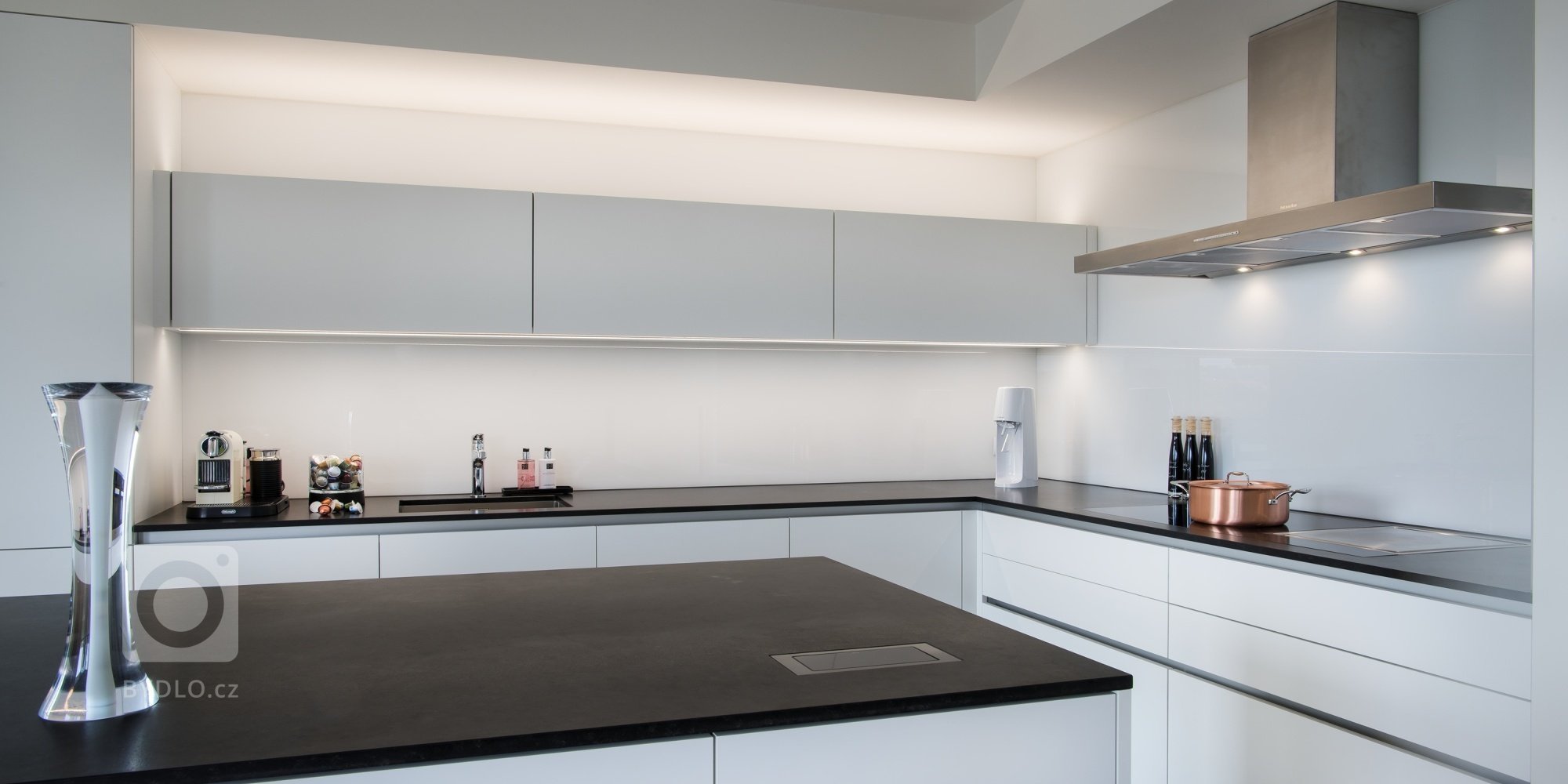 Kuchyň EGGERSMANN, byt, realizace 2018. Provedení je melamin Tarent 2700 KU bílá mat, bezúchytkový systém e:sing hliník, doplňky Blanco. Pracovní deska je žula…