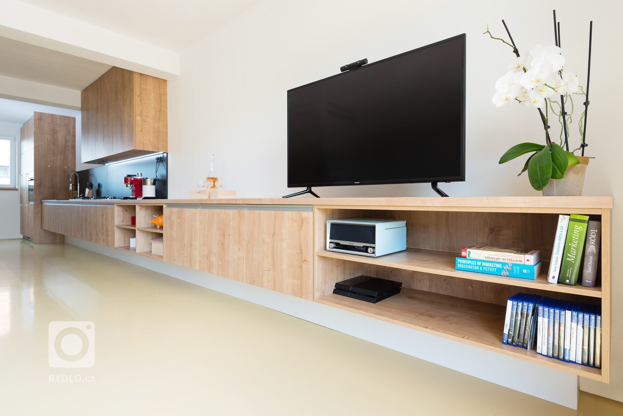 Moderná a zároveň funkčná kuchynská linka, ktorá plynulo prechádza do obývacej zostavy pozdĺž celého interiéru.
