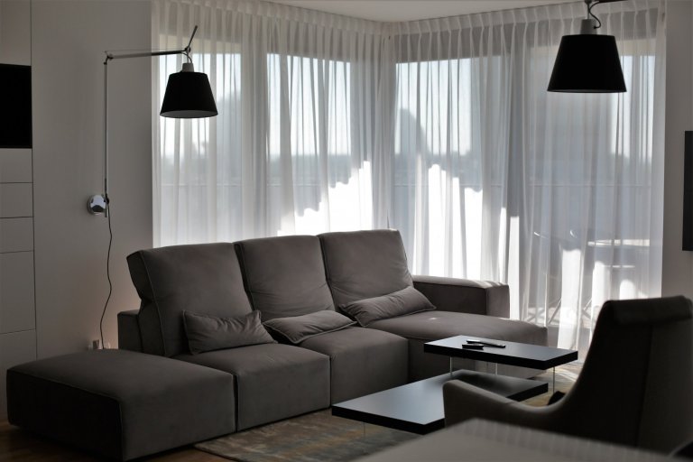 Dominantní nástěnné lampy Tolomeo od Artemide "dohlíží" na dění v obytném prostoru.