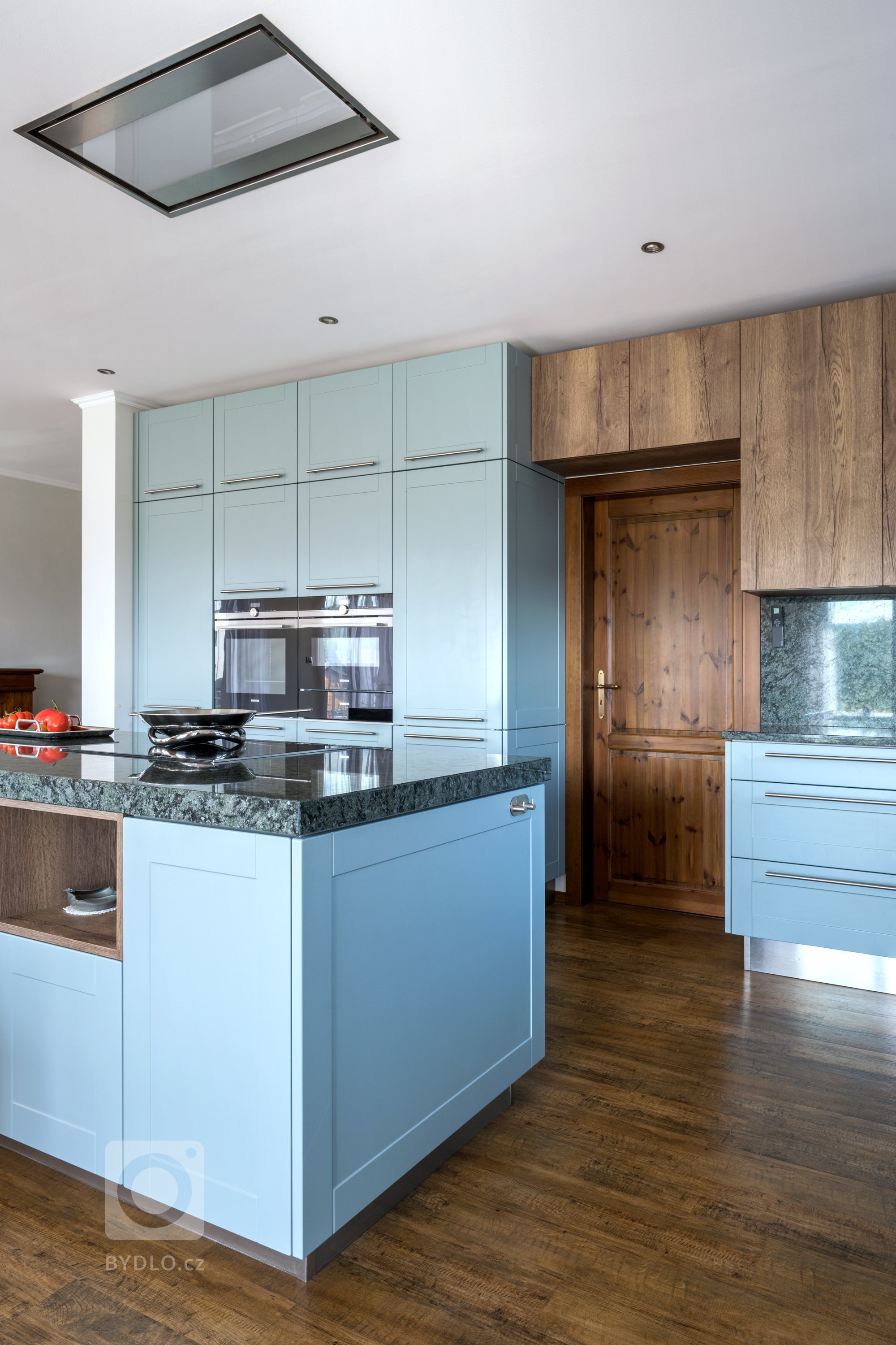 Vkusně zapracované dřevěné dveře do kuchyňské linky.