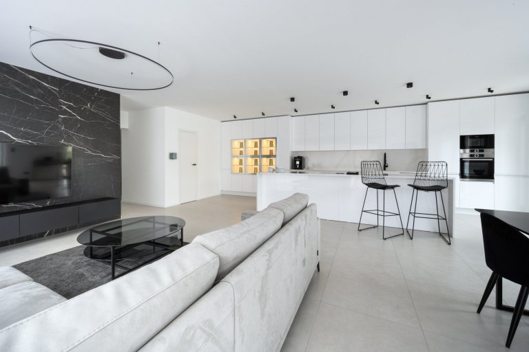 Sestava v hladkém, čistém designu Pure tvoří celou jednu stranu místnosti.
Geometricky vyrovnaná a přesto členitá, designová a zároveň praktická, nabízí ideální podmínky pro kulinářské aktivity i pro rodinný život. Bílé dvířka skříněk jsou lakované v lesku White, který se snadno udržuje a odolává stopám času i rodinných příslušníků. 
