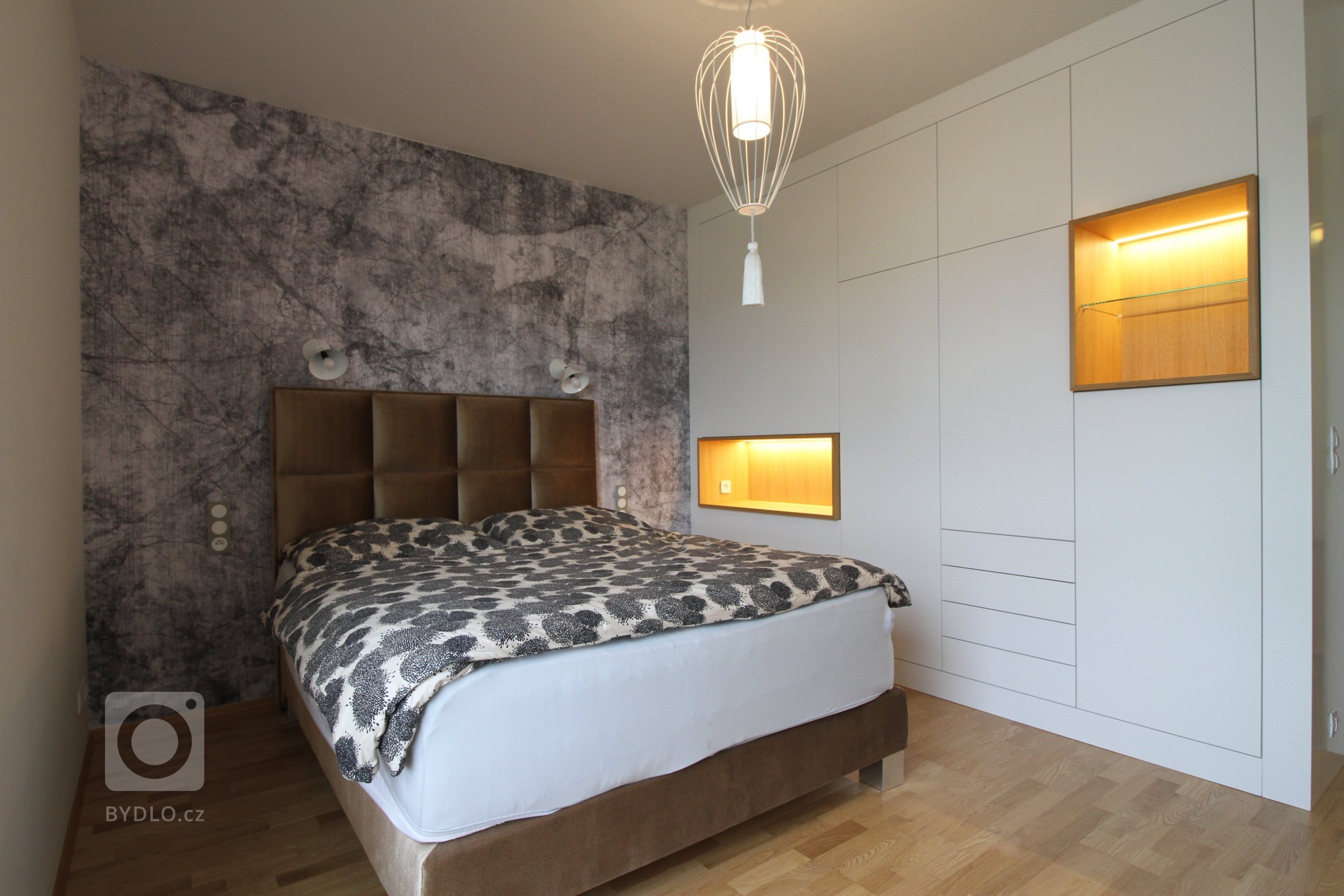 Interiér ložnice s italskou tapetou a svítidly, šatní skříň podle autorského návrhu.
