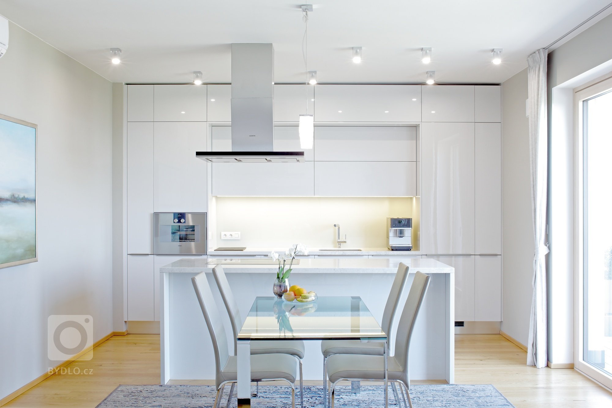 Lesk, sklo a bílá barva &ndash; zaručený recept pro vzdušnou a elegantní kuchyni.&nbsp;Jak vidíte, s žádnou jinou barvou se tady prakticky nepracovalo (matná…